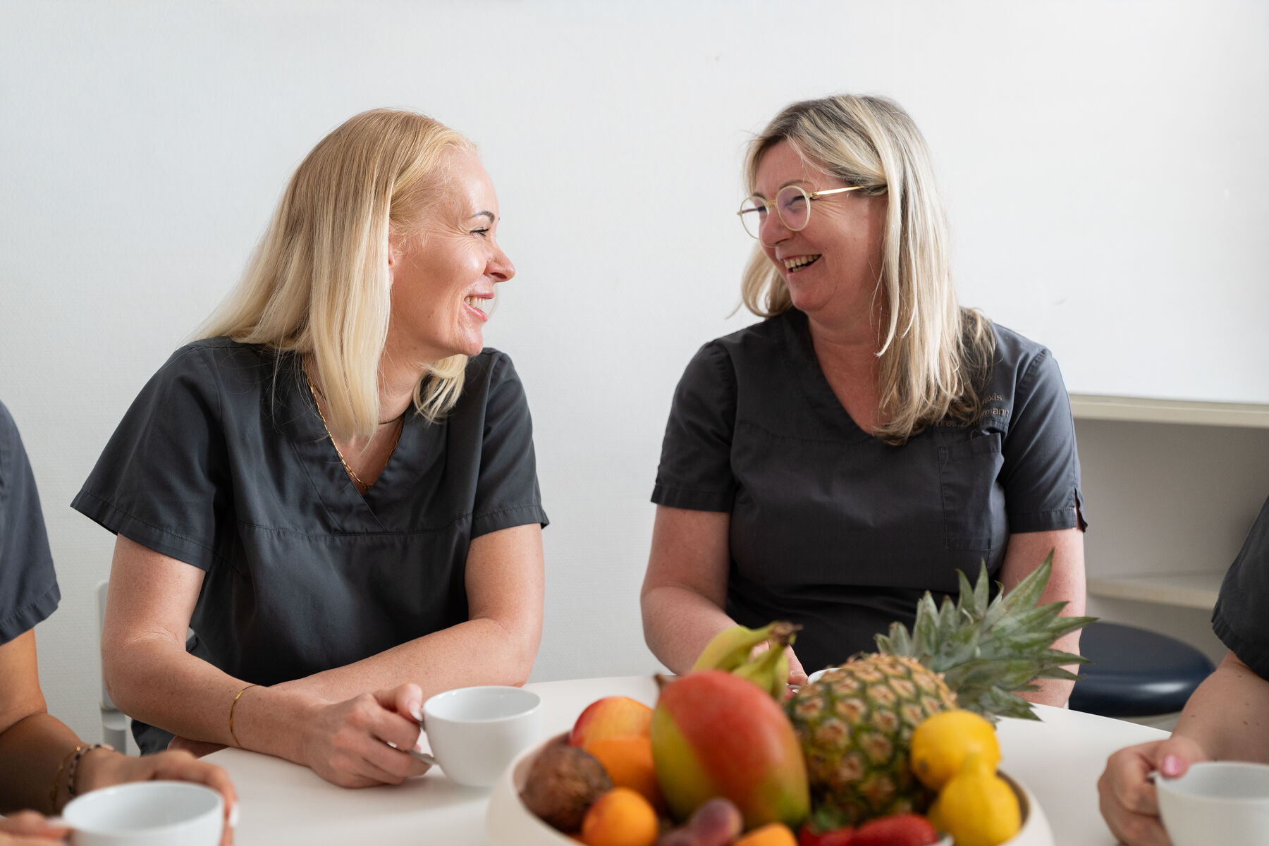 Das Praxisteam sitzt beim gemeinsamen Frühstück mit Obst am Tisch
